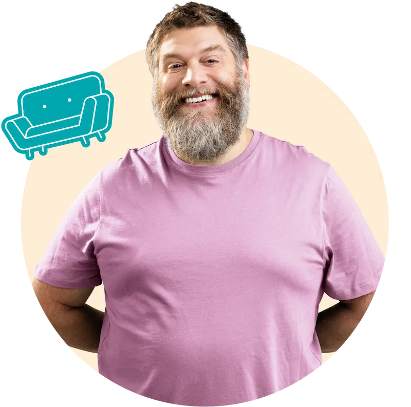 A bearded middle aged man smiling in a pink t-shirt