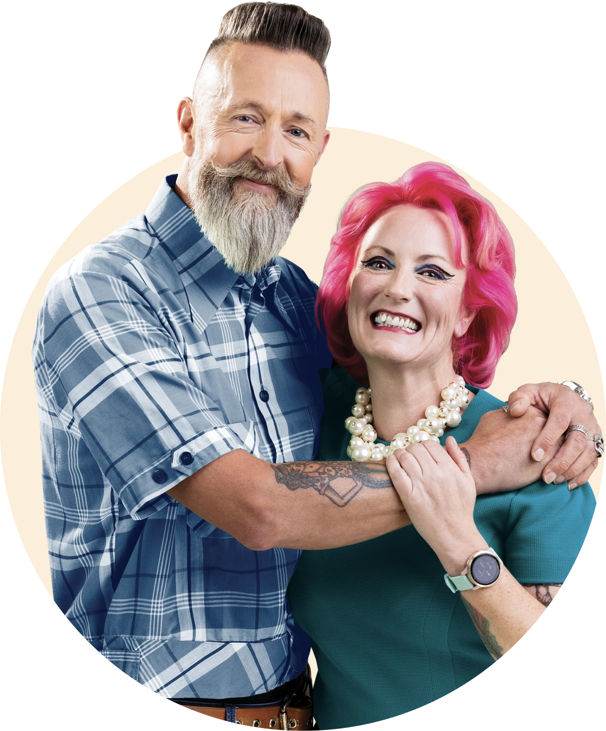 A happy couple, A bearded man in a blue checked shirt putting his arms around a pink haired lady wearing a teal green t-shit