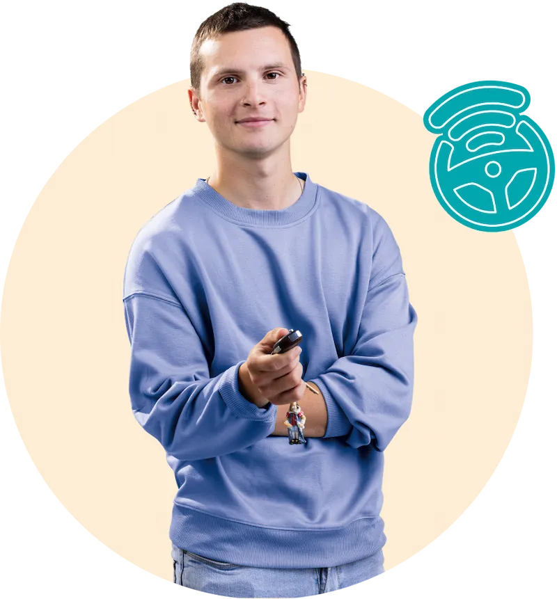 A young man in pale blue sweater holding a key fob towards the camera